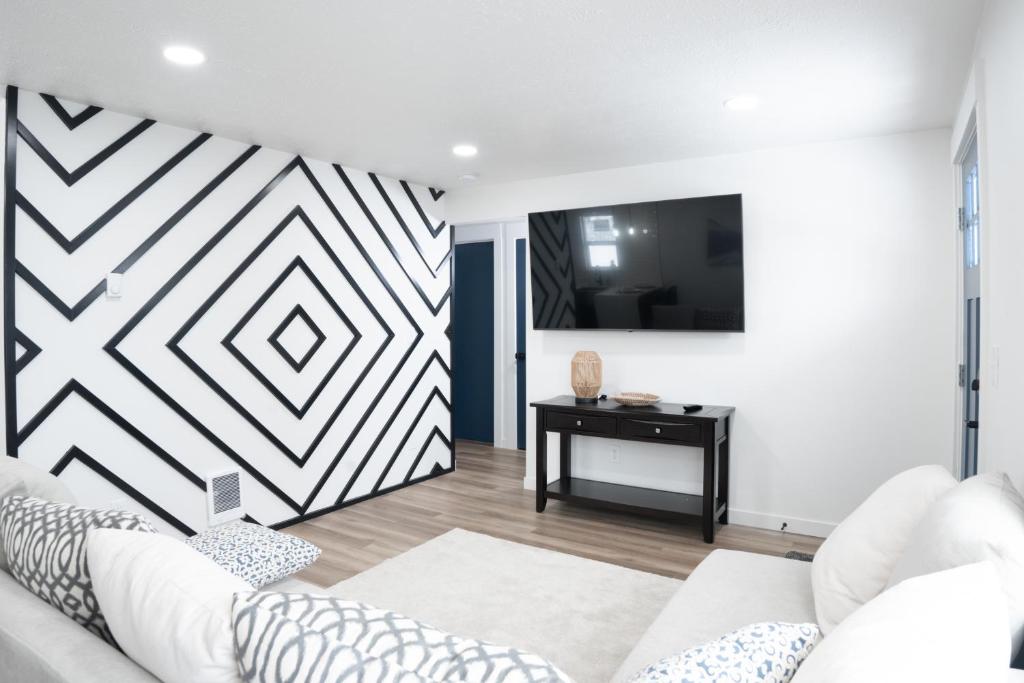 een woonkamer met een witte bank en een tv bij Beautiful Remodeled Home 3 BD 1 BTH w Hot Tub in Spokane Valley