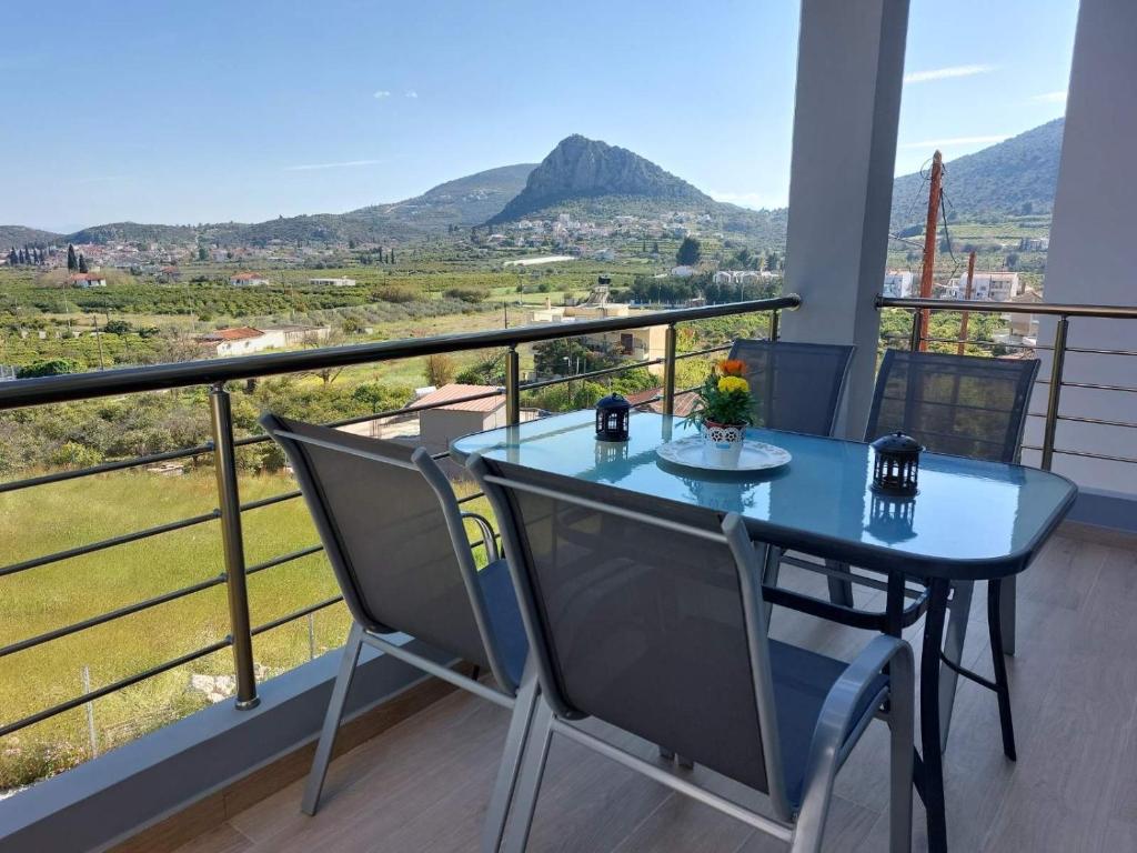 een blauwe tafel en stoelen op een balkon met uitzicht bij Endless View Apartment in Nafplio