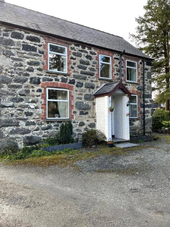 an old stone house with a white door at Rhydydefaid Bed and Breakfast, Guesthouse in Frongoch, Snowdonia in Frongoch