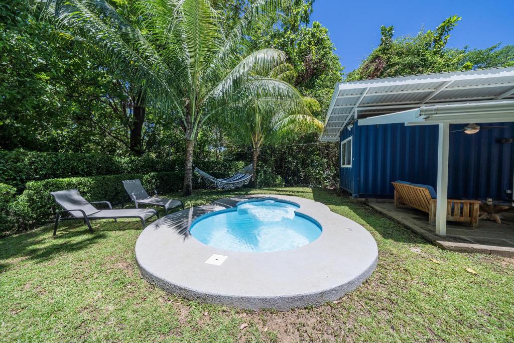 a pool in the yard with a chair and a table at Cute, modern Tiny home with pool for 2 people in Playa Potrero in Potrero