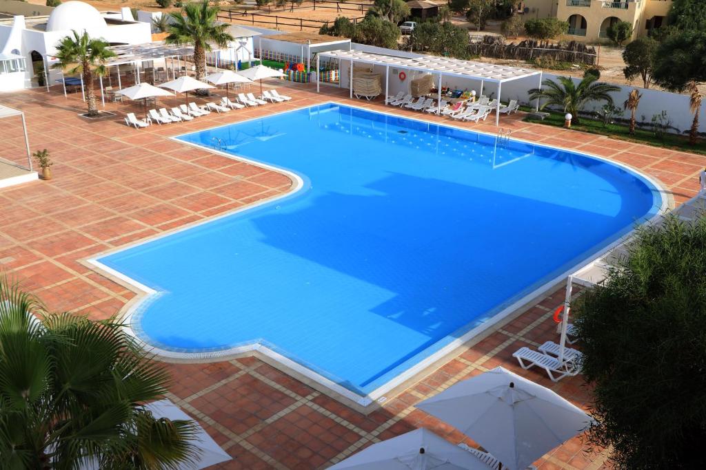 an overhead view of a large blue swimming pool at Hotel Riad Meninx Djerba in Djerba