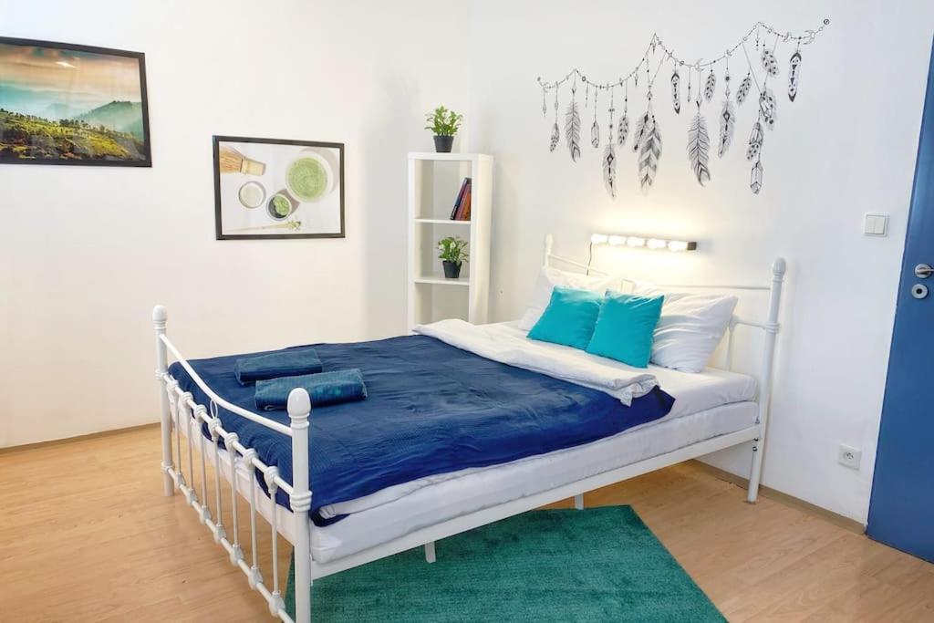 una camera da letto con un letto bianco con cuscini blu di Boho Studio - Brno Cejl a Brno