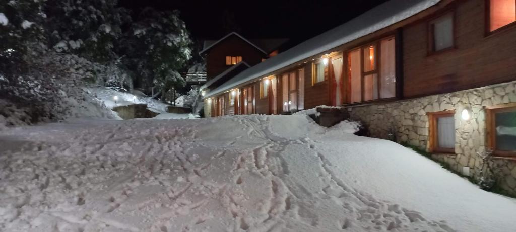 ein Schneehaufen vor einem Gebäude in der Unterkunft Apart Hotel Altos de Antilhue in Villa La Angostura