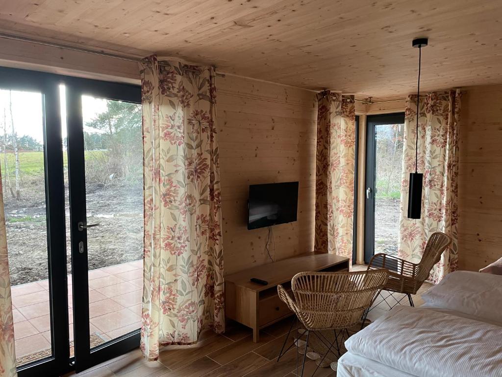 Dormitorio con cama, escritorio y TV en Glamping Challet Slunečno Český ráj, en Dobšín