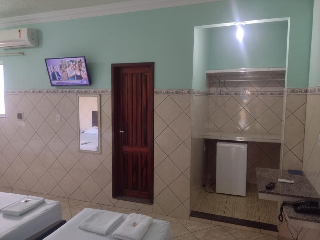 a bathroom with a toilet and a red door at Hotel Val-de-Cans Aeroporto in Belém