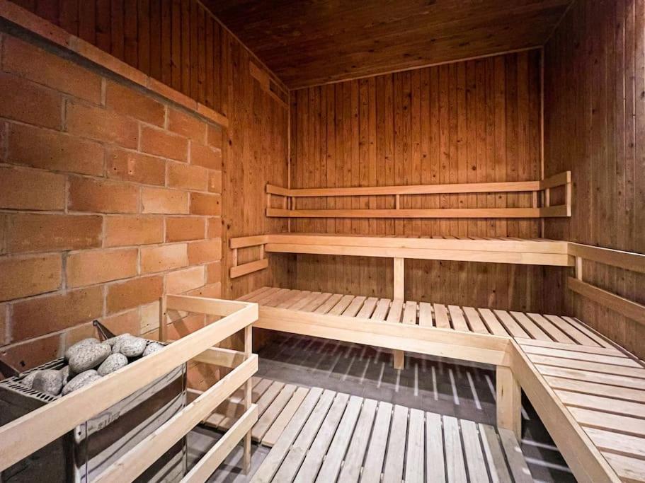 eine Sauna mit Holzregalen und einer Ziegelwand in der Unterkunft Sauna Apartment - Brno(x) Cejl in Brünn