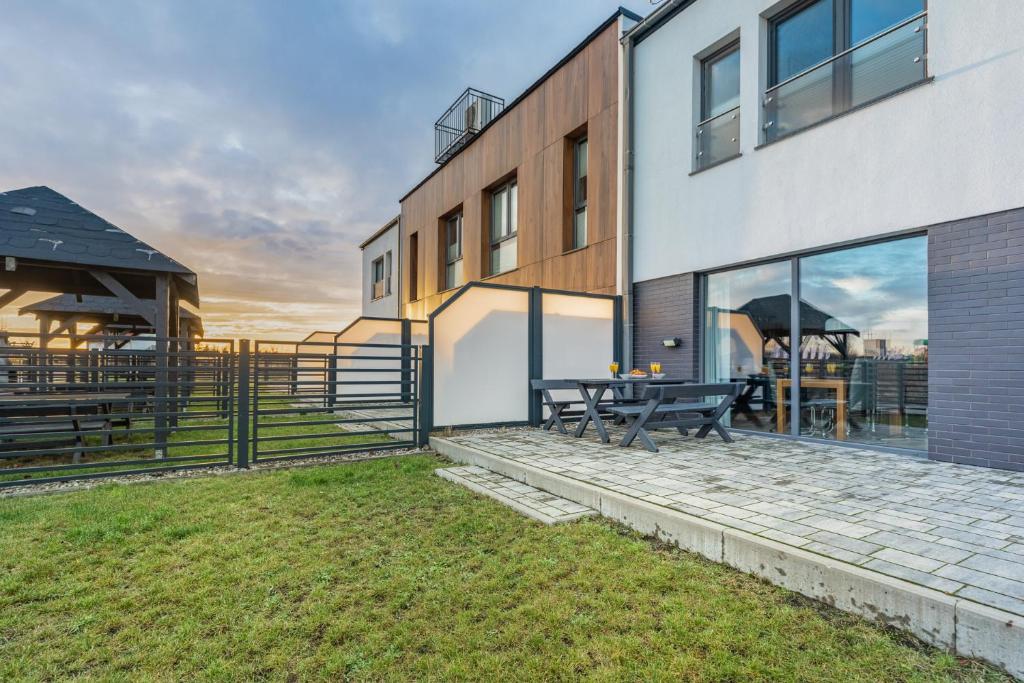 a house with a patio and a table in the backyard at Exclusive Zefir Sauna & Grill in Międzywodzie