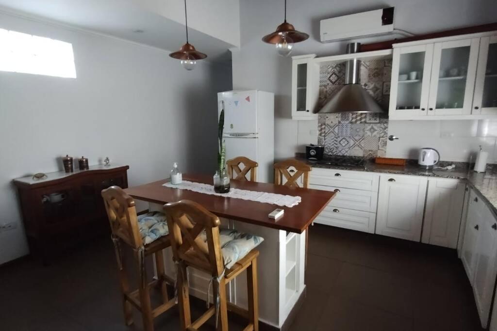 cocina con mesa, sillas y nevera en Alojamiento Entero, Aeropuerto Ezeiza en Ezeiza