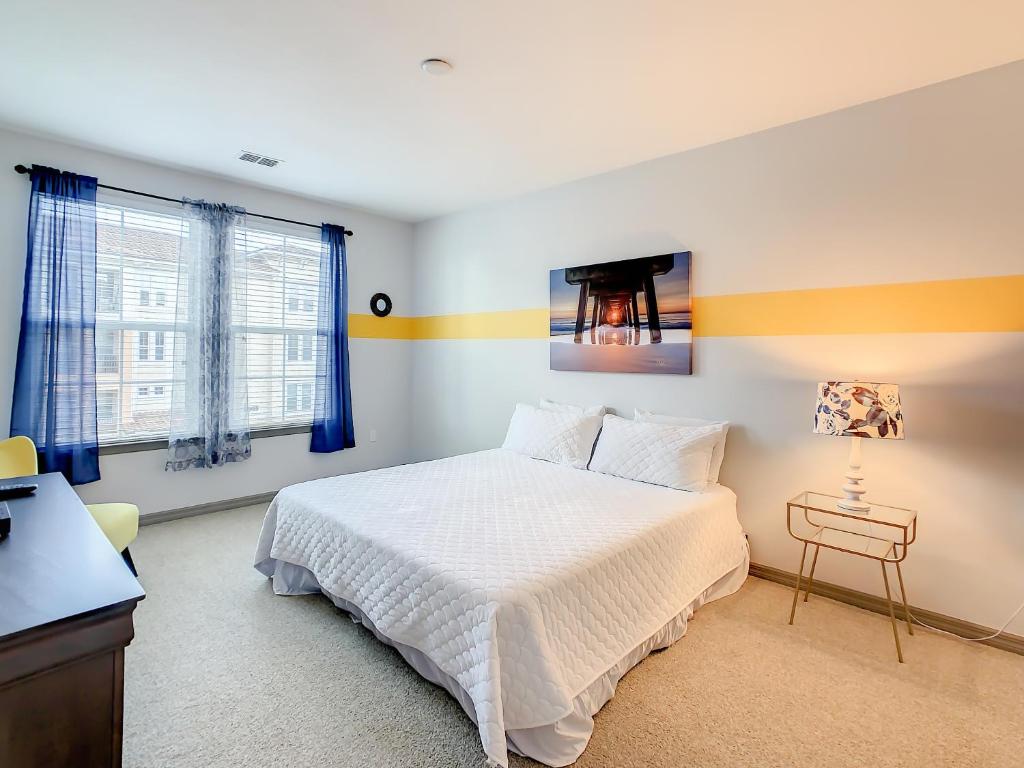 um quarto com uma cama, uma secretária e janelas em Spacious Apartment Near Disney em Kissimmee