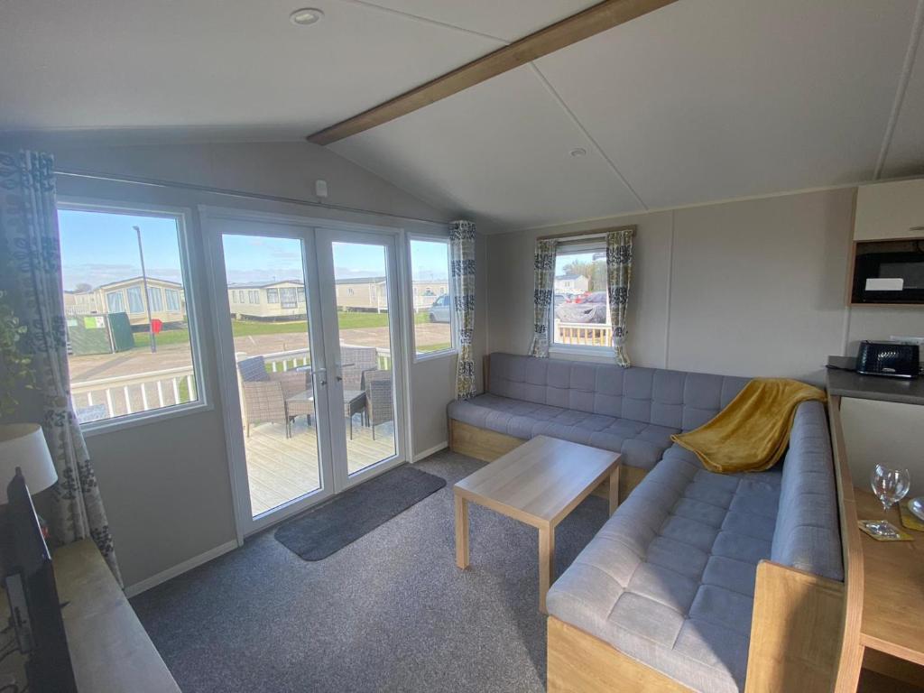 a living room with a couch and a table at Cosy holiday home at Romney Sands in New Romney