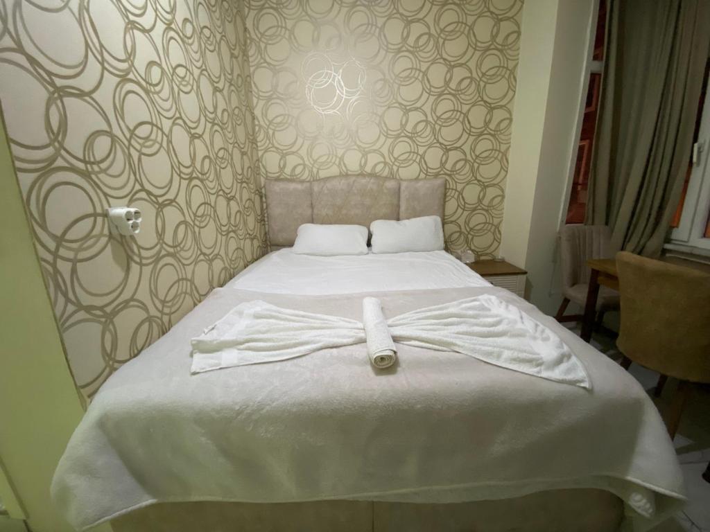 um roupão branco numa cama num quarto em Yildiz Hotel em Istambul