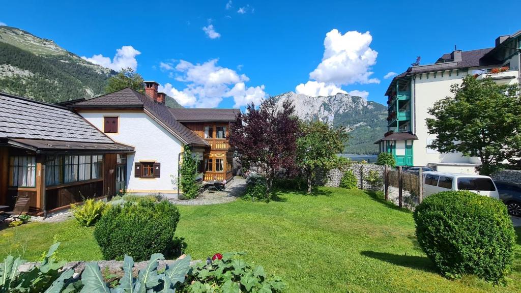 a house with a yard with mountains in the background at Ferienwohnung Engl Haus in Altaussee