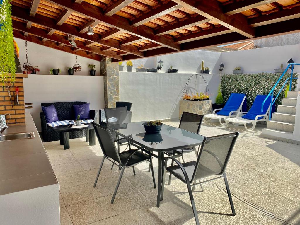 een patio met een tafel en stoelen bij Casa dos Montes in Alvor