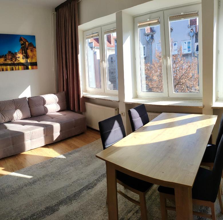 a living room with a table and a couch at Apartament Gdańsk Starówka in Gdańsk
