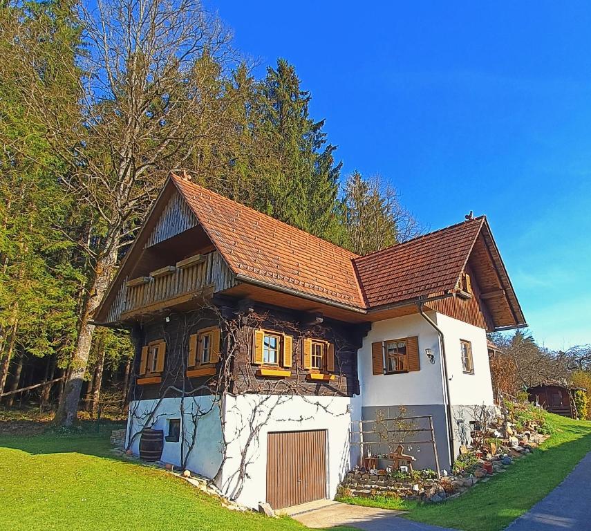 a small white house with a brown roof at Pension Treissmann in Pichling bei Stainz