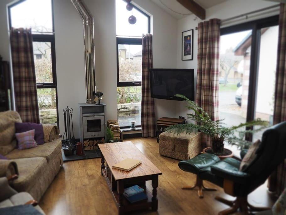 uma sala de estar com um sofá e uma mesa em Fern Lodge Angus, Kirriemuir em Angus
