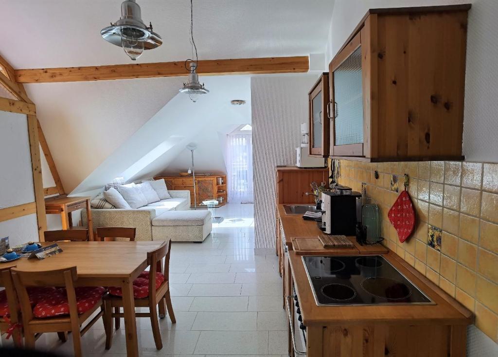 eine Küche und ein Wohnzimmer mit einem Tisch und einem Sofa in der Unterkunft Ferienwohnung Katja in der Villa Seeblick in Bad Saarow