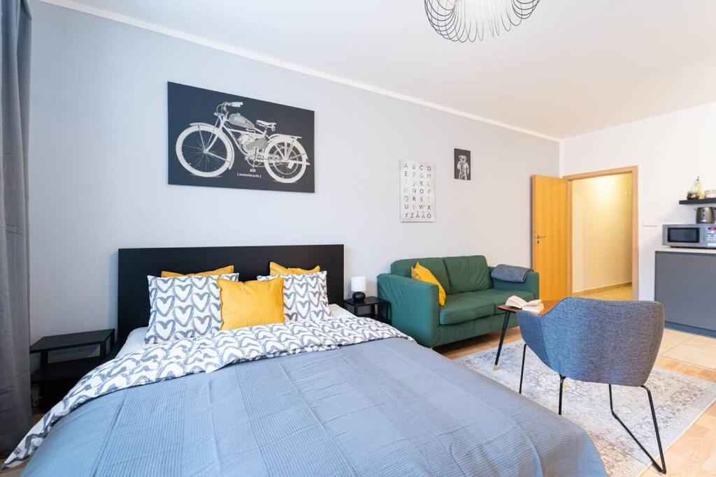 - une chambre avec un lit bleu et un canapé vert dans l'établissement Astronaut Studio - Brno Centrum, à Brno