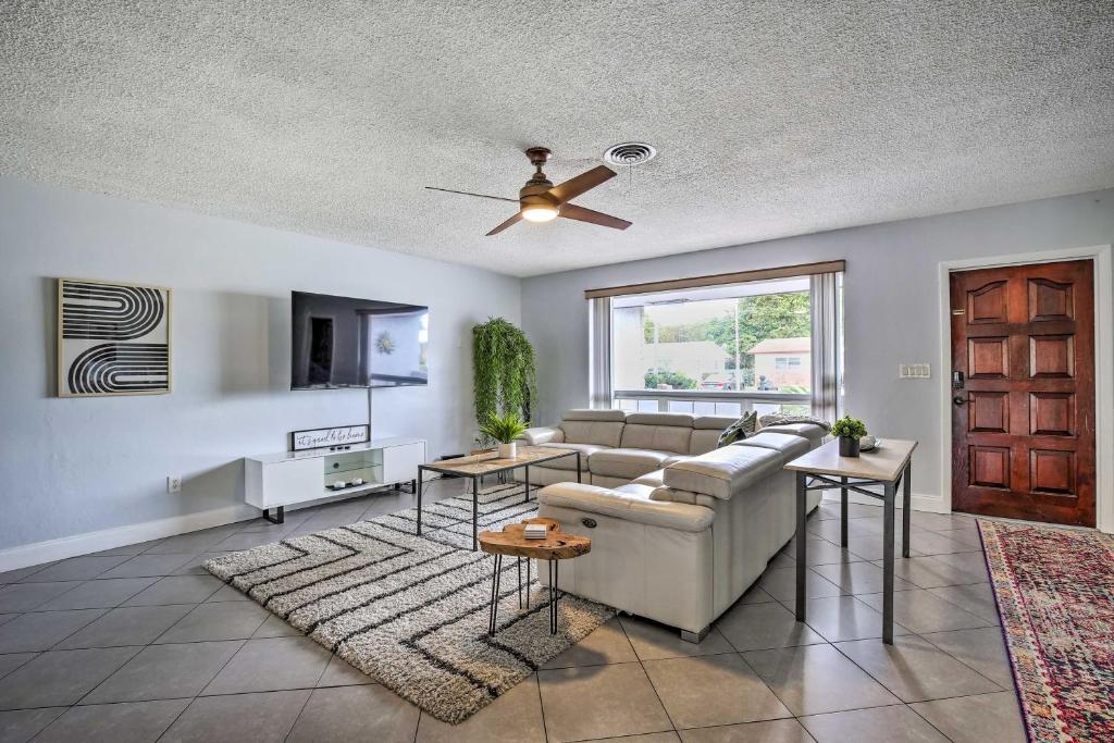 a living room with a couch and a ceiling fan at Private Pool and Dock Coconut Creek Home! in Coconut Creek