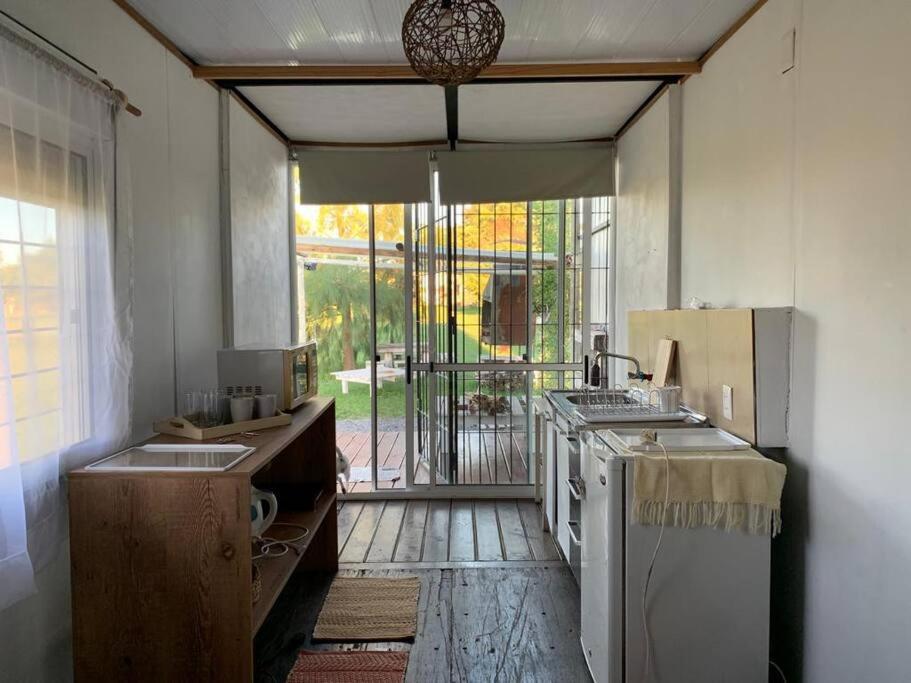 a kitchen with an open door to a yard at Casa Contenedor y espacio verde in Paysandú