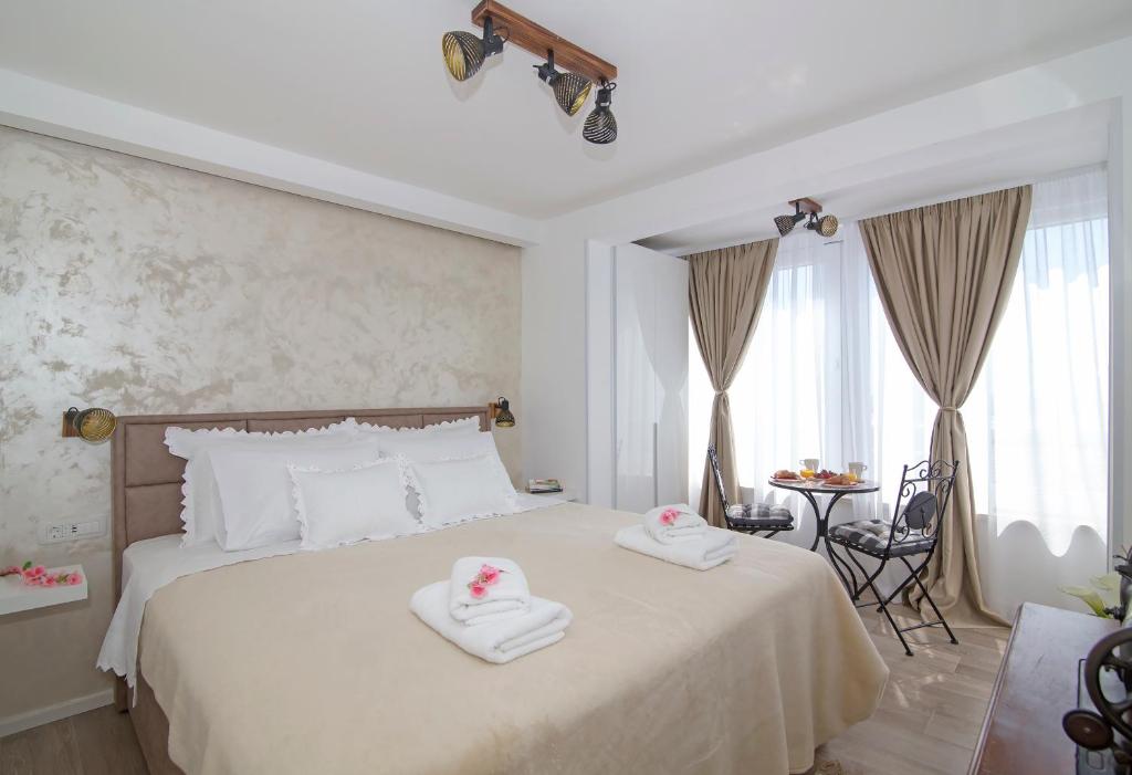 杜布罗夫尼克Blue Cliff Apartment的卧室里有一张白色的床，床上有两条毛巾