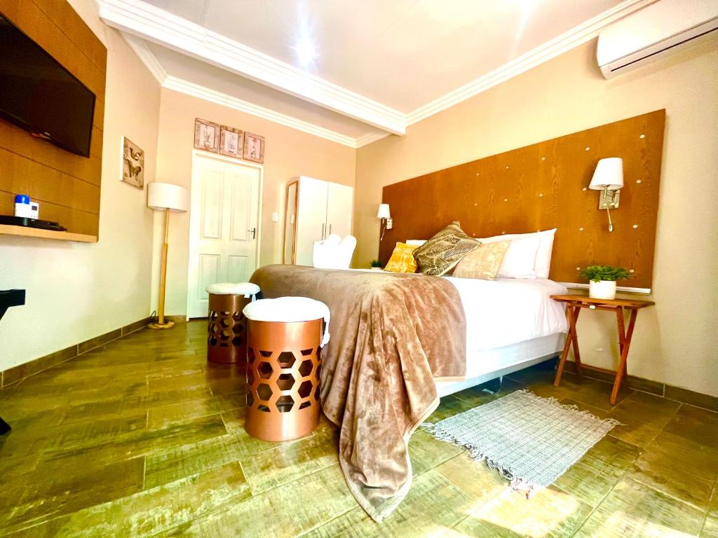 a bedroom with a bed with a large wooden headboard at Swane’s guesthouse in Rustenburg