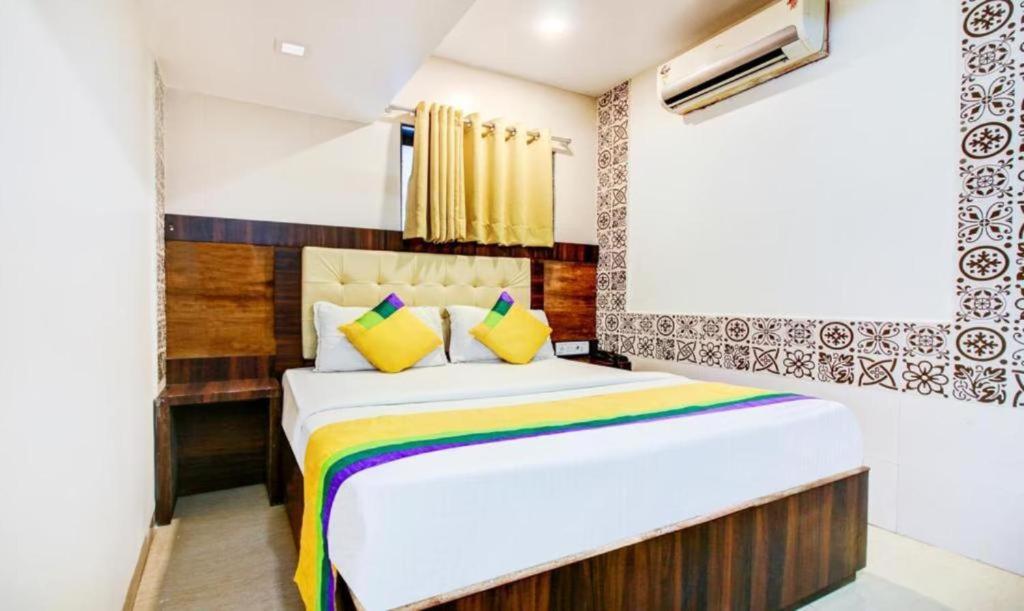 una camera da letto con un grande letto con una coperta colorata di KALPANA RESIDENCY - Near US Embassy a Mumbai