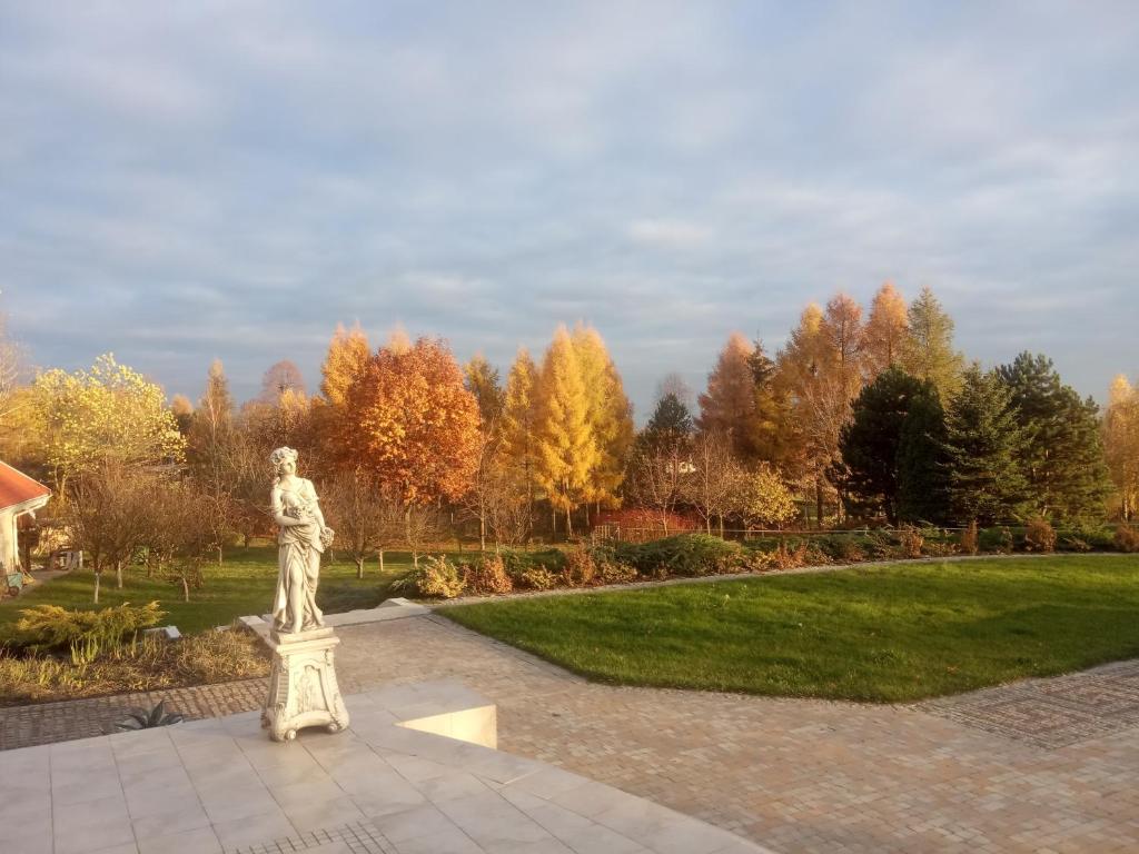 una statua in un parco con alberi sullo sfondo di Rezydencja Pod Platanem 