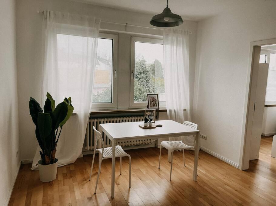 a dining room with a table and two windows at Zentral, gemütlich, Messe nah! BE1L in Essen