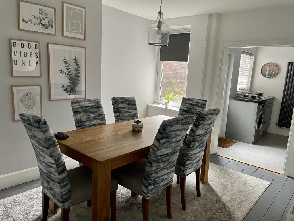 uma sala de jantar com uma mesa de madeira e cadeiras em Modernised Cottage in the Heart of Sketty em Swansea