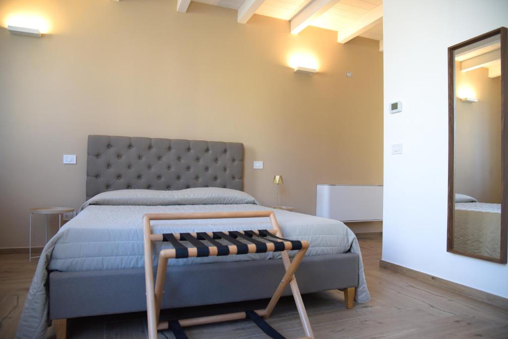 - une chambre avec un lit et un banc dans l'établissement Serenity Apulian Rooms, à Trepuzzi