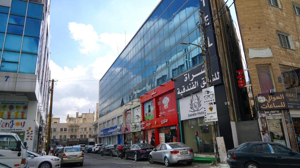 eine belebte Stadtstraße mit Autos vor den Gebäuden in der Unterkunft Sorate Hotel Apartment in Amman