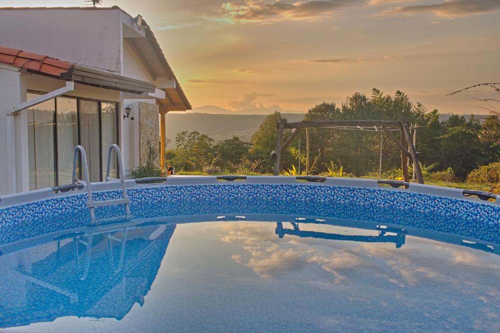 a swimming pool in front of a house at Villa Namaste - Cabaña Albores in Curití