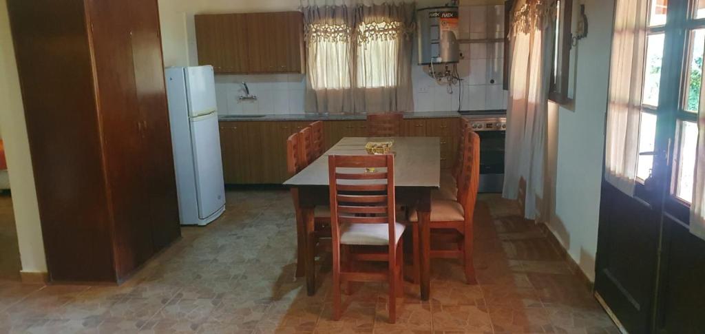 uma cozinha com uma mesa e cadeiras e um frigorífico em La Soñada de La Majadita em San Agustín de Valle Fértil