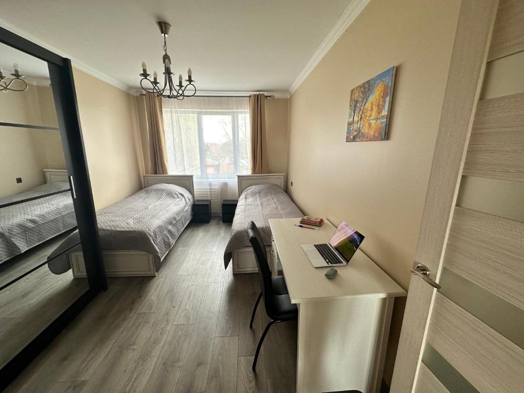 Habitación con 2 camas y escritorio con ordenador portátil. en Moderns, gaišs, plašs! A++ 3 istabu dzīvoklis, en Riga
