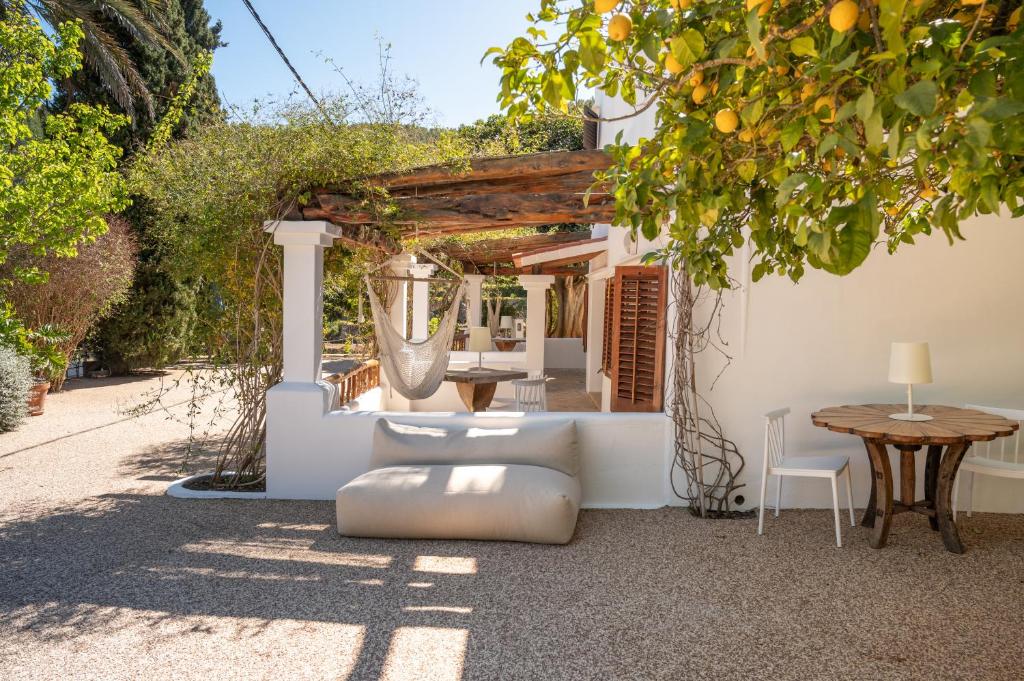 d'une terrasse avec une table, des chaises et un arbre. dans l'établissement Valley Club Ibiza - Boutique Agroturismo, à Sant Joan de Labritja