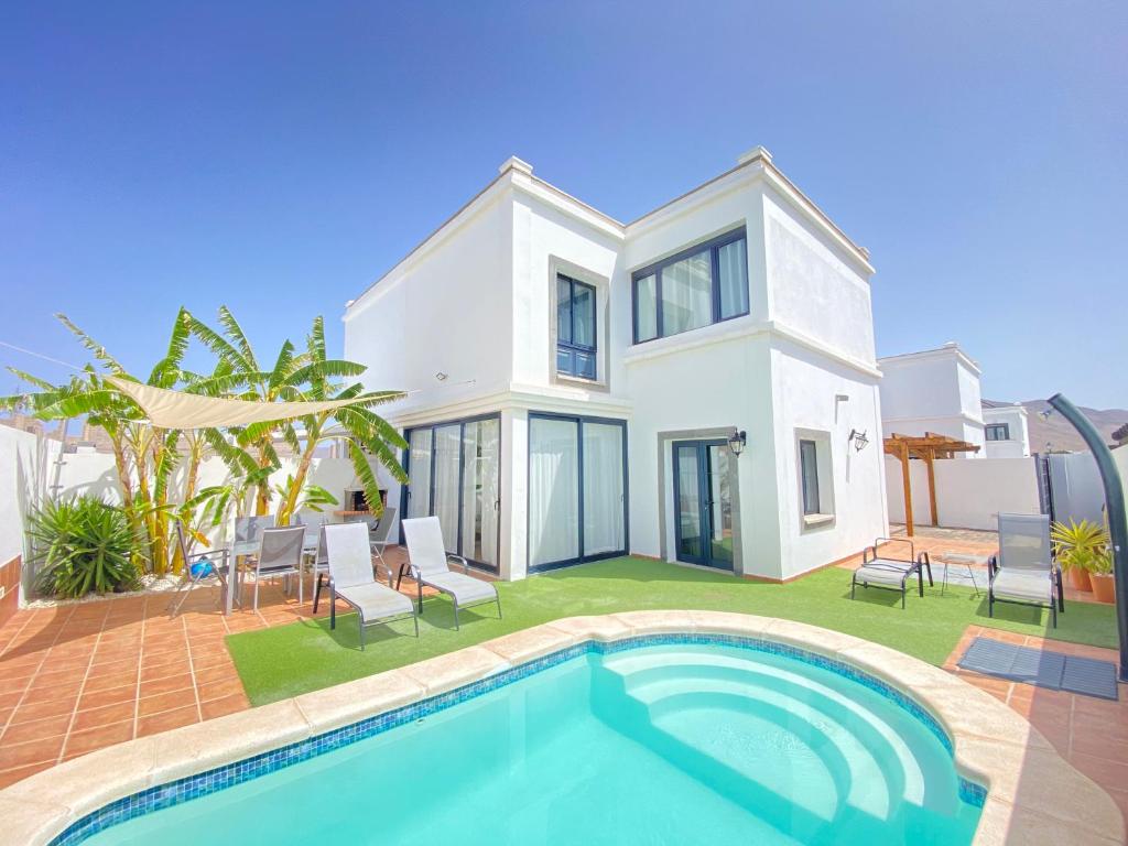 une villa avec une piscine en face d'une maison dans l'établissement Villa Magma, à Yaiza