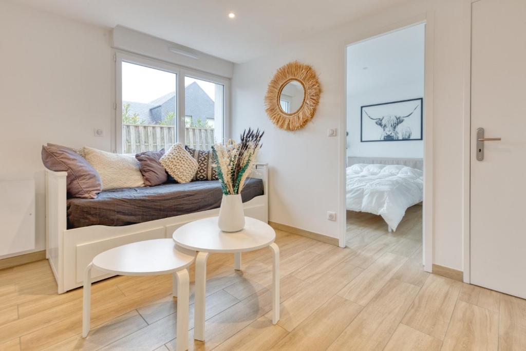 uma sala de estar com um sofá e uma mesa em La Dune de Sable Sainte Marguerite em Pornichet