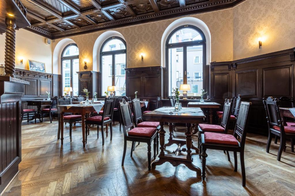a restaurant with tables and chairs and windows at Hotel Mauritius in Crimmitschau