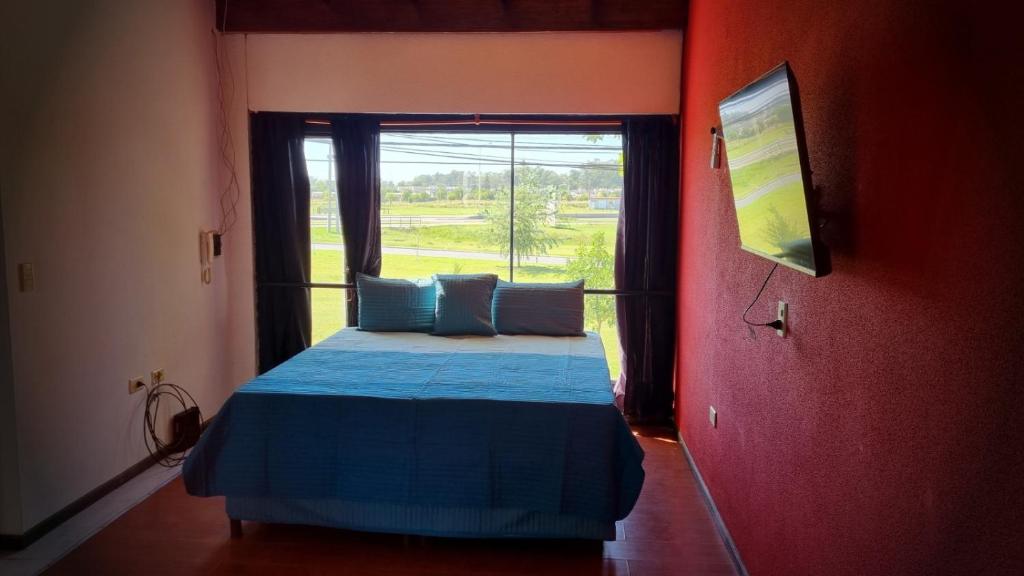 a bedroom with a blue bed and a window at Galeano Aparts in Santa Rosa