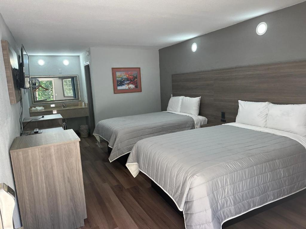 Habitación de hotel con 2 camas y TV en Budget Inn Express, en Columbia