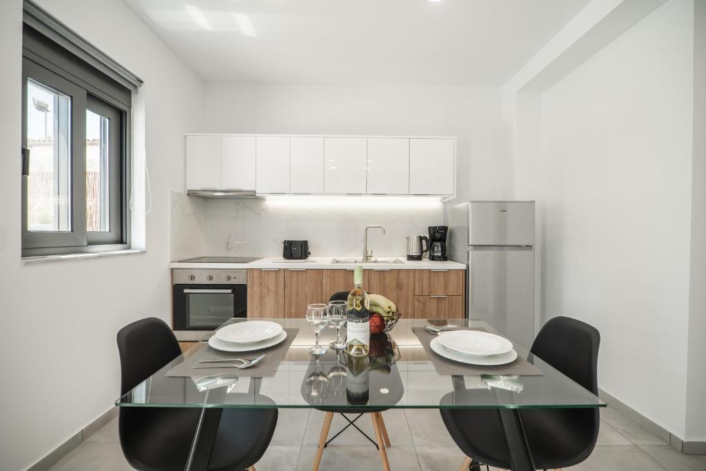 a kitchen with a glass table and chairs in it at Kiani Apts in Kalyves