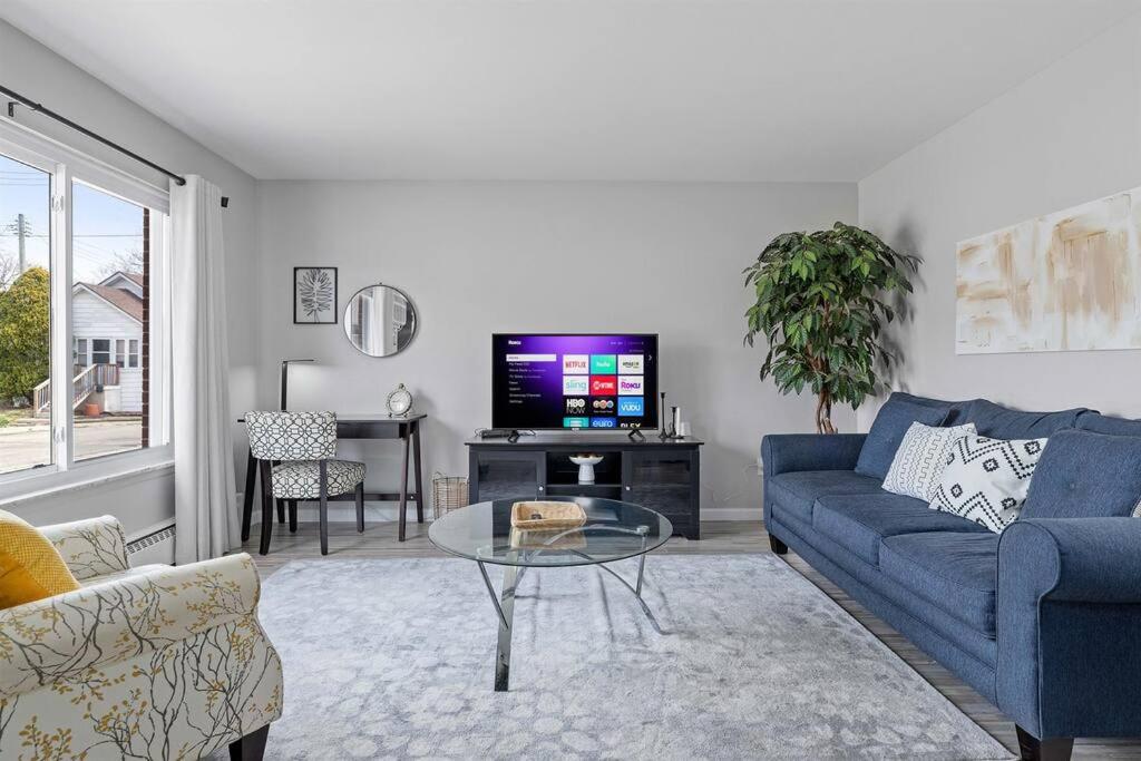 a living room with a blue couch and a tv at Bright & Comfy 1 Bedroom Flat - Hollywood Suites in Mount Clemens