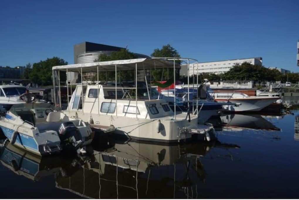 una barca è ormeggiata in un porto turistico con altre imbarcazioni di Bateau pénichette atypique a Nantes