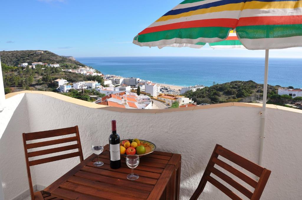 a table with a bowl of fruit and a bottle of wine at SALEMA - Amazing View Apartment in Salema