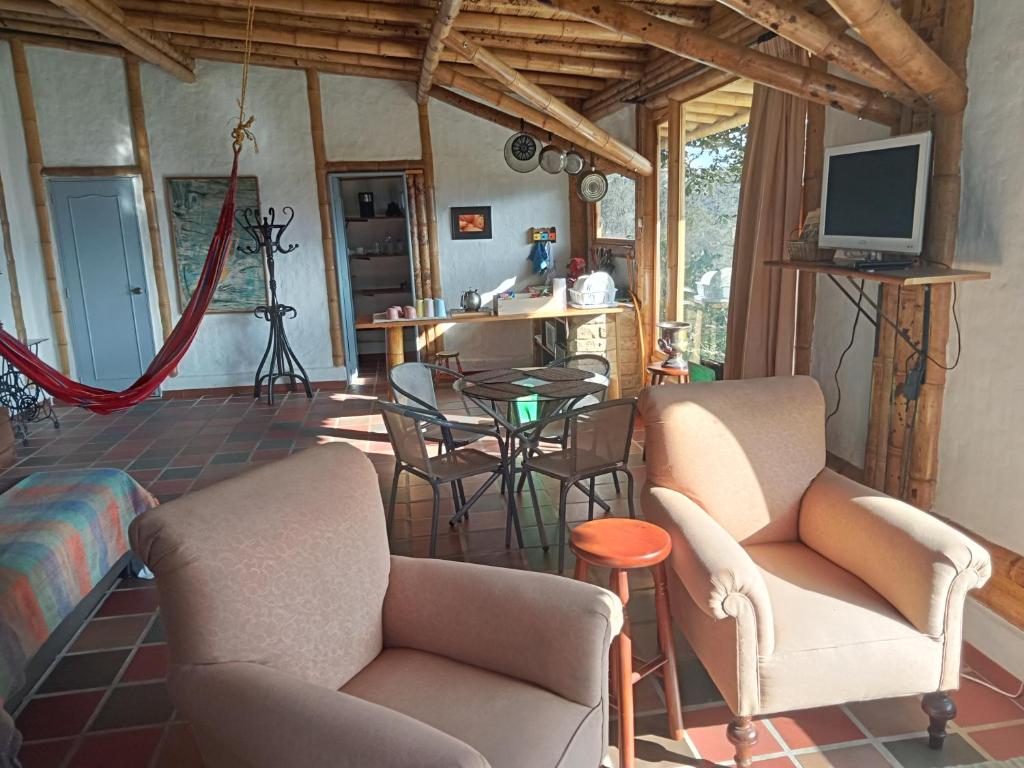 TV a/nebo společenská místnost v ubytování HOSTAL CASA DE GUADUA/ THE BAMBOO HOUSE