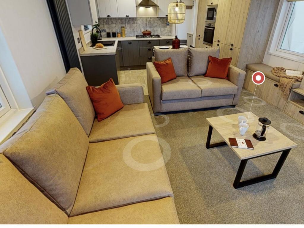 uma sala de estar com um sofá e uma mesa em Sherwood Lodge em Cheddar