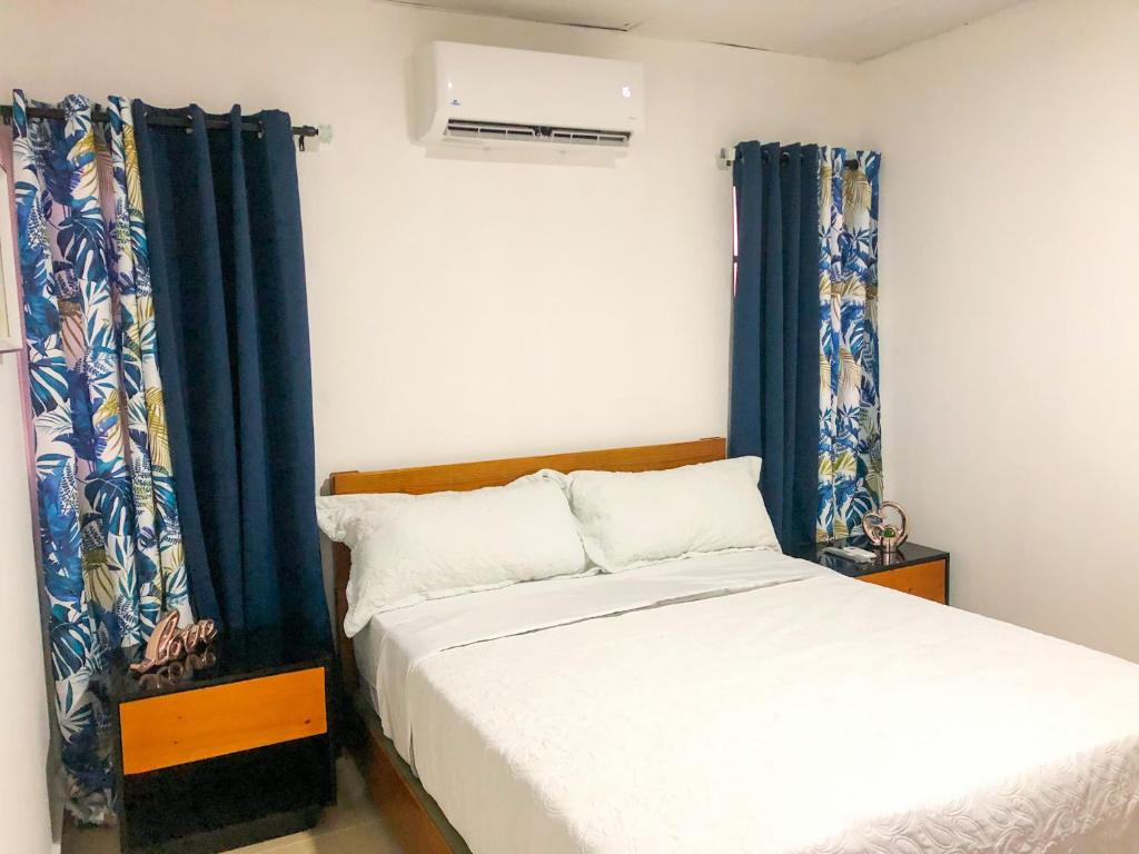 een slaapkamer met een bed en een raam met gordijnen bij Ocean View Apart. In Down town in San Felipe de Puerto Plata