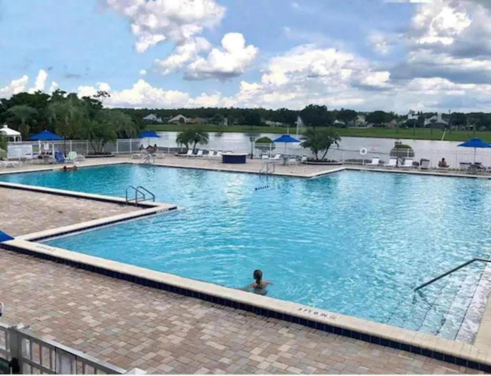 una gran piscina con una persona en el agua en Orlando Vacation Apartment 3919 en Orlando