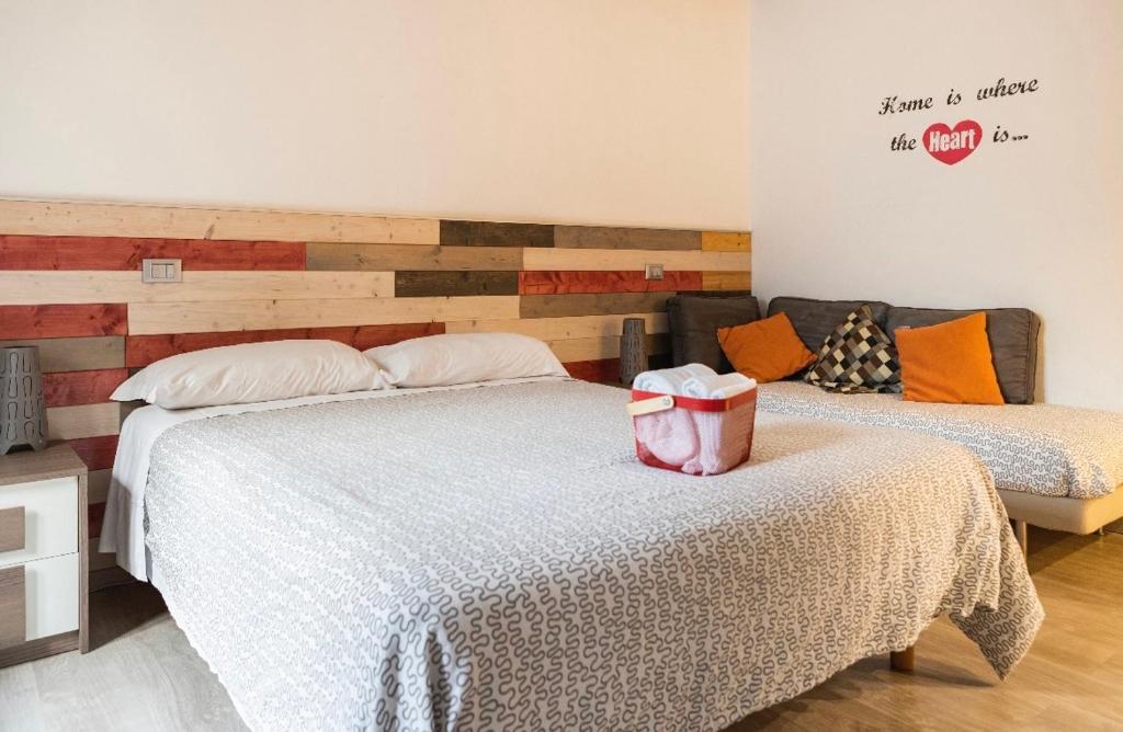 a bedroom with two beds and a wall with a wood accent at WhatsHouse Roma in Rome